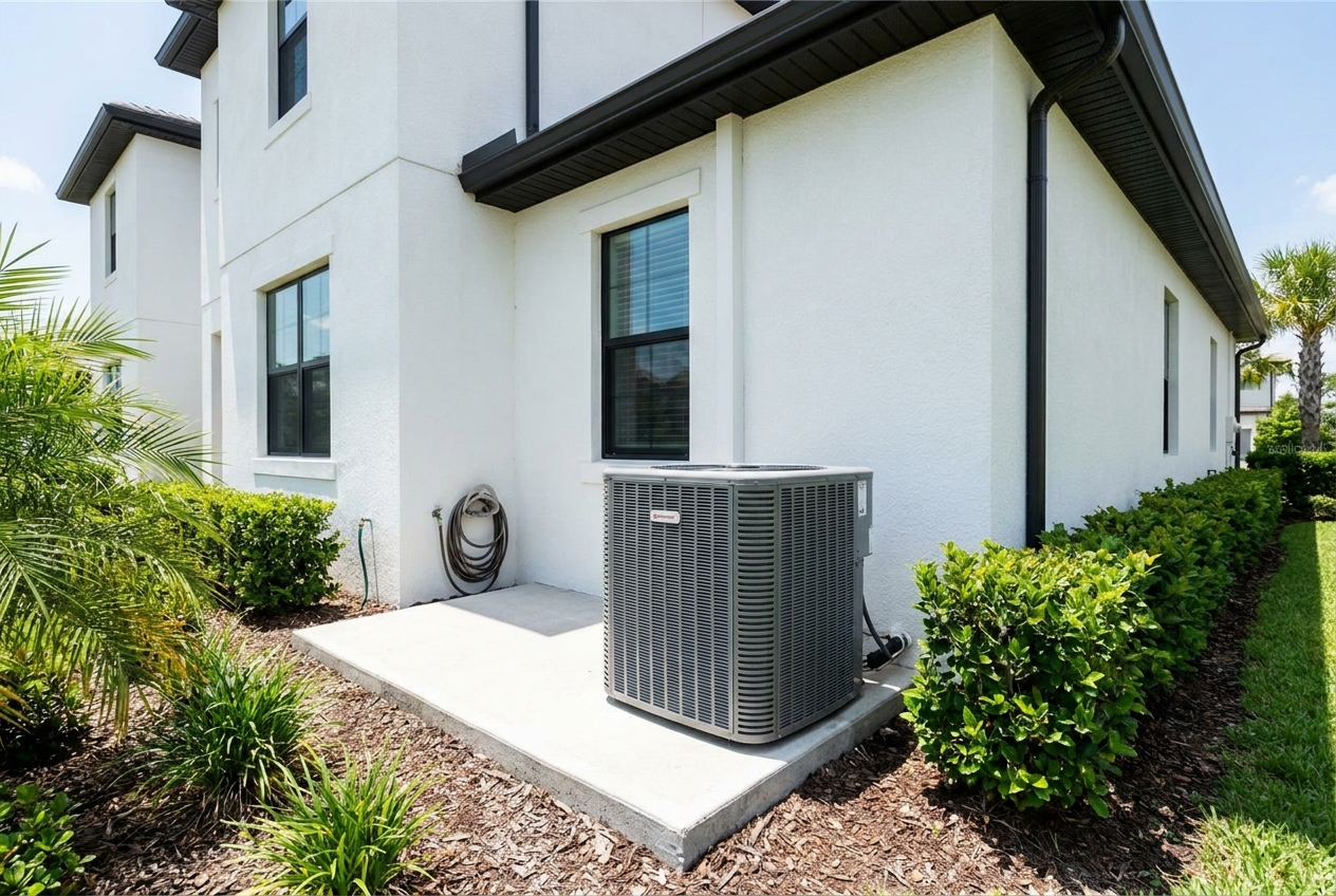 A new residential AC condenser on a pad beside a white Florida home